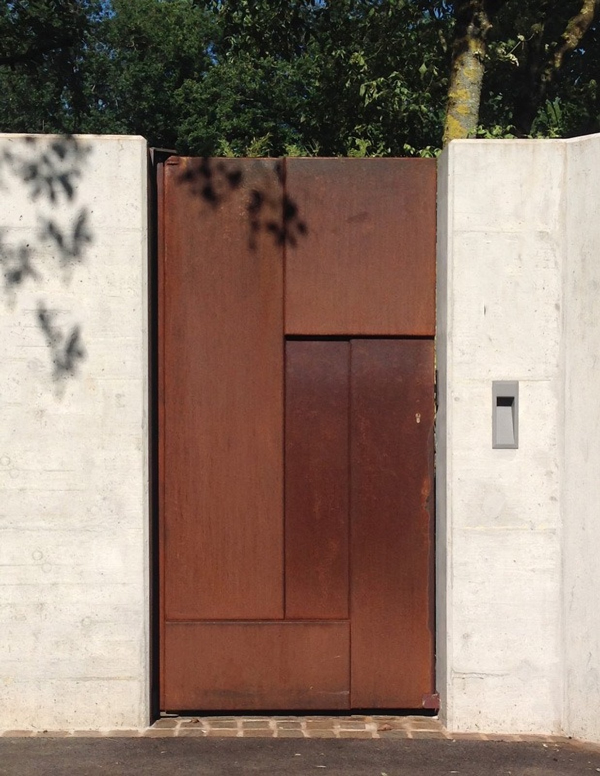 Portail en acier Corten sur mesure entre deux murs en béton